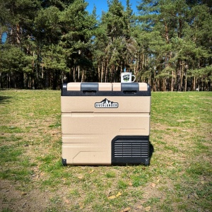 Frigiderul auto Overlander în natură, într-un decor de camping.