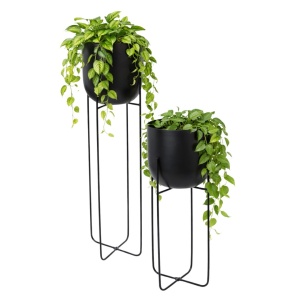 Set of two decorative planters for plants and flowers, made of black metal, with tall, slender legs.