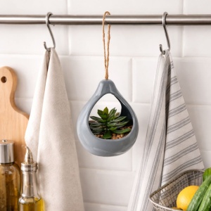 Artificial succulent plant in a grey teardrop-shaped ceramic holder, 14 cm, with a twine hanger.