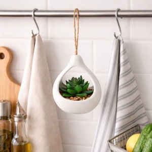 Artificial succulent plant in a white teardrop-shaped ceramic holder, 14 cm, with a twine hanger.