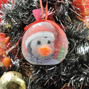 Glob decorativ roșu - Pinguin cu căciulă și eșarfă, între brăduți