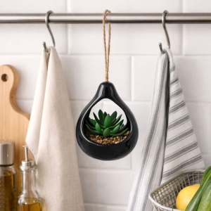 Artificial succulent plant in a black teardrop-shaped ceramic holder, 14 cm, with a twine hanger.