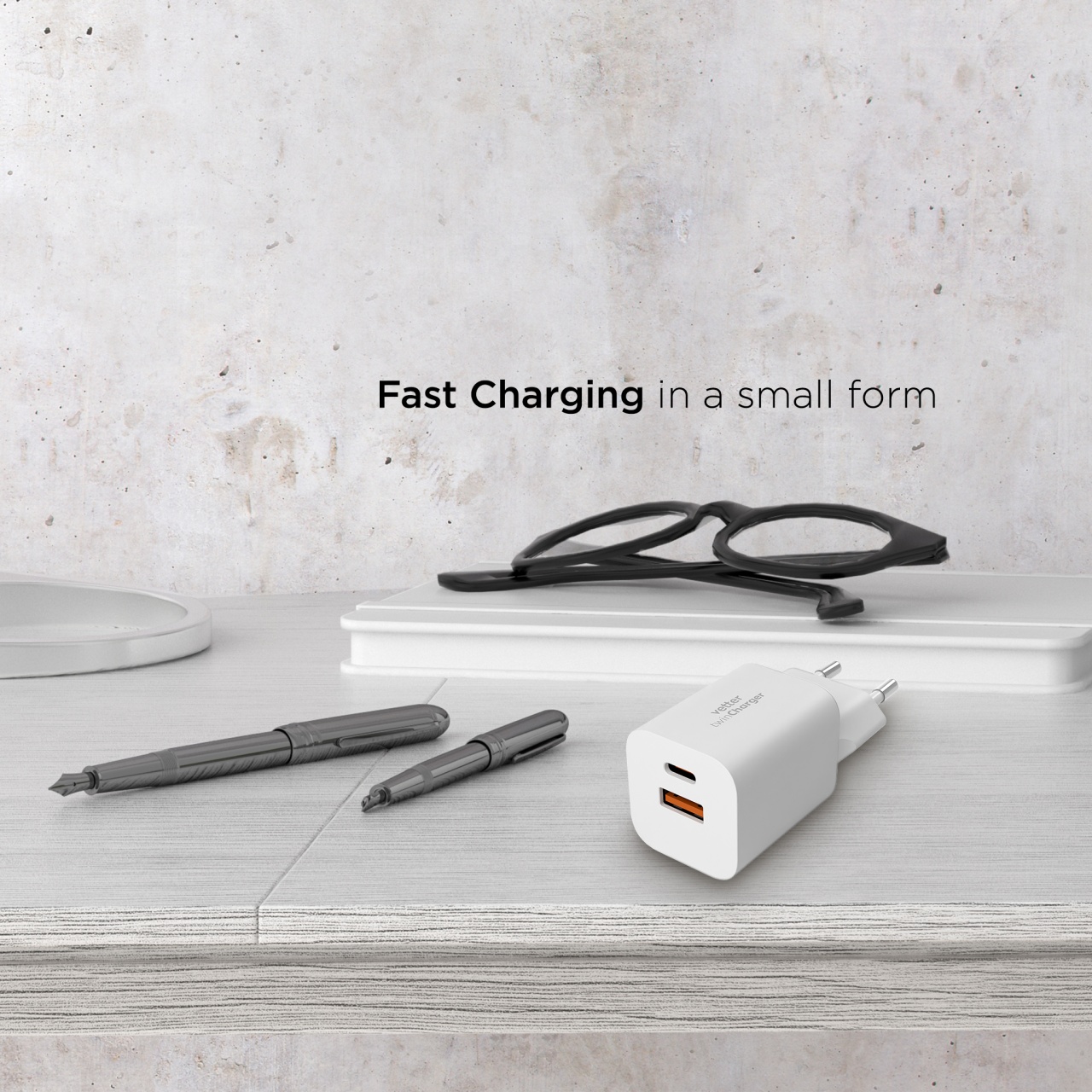 Incarcatorul Twin Charger 33W pe un birou, langa ochelari si pixuri