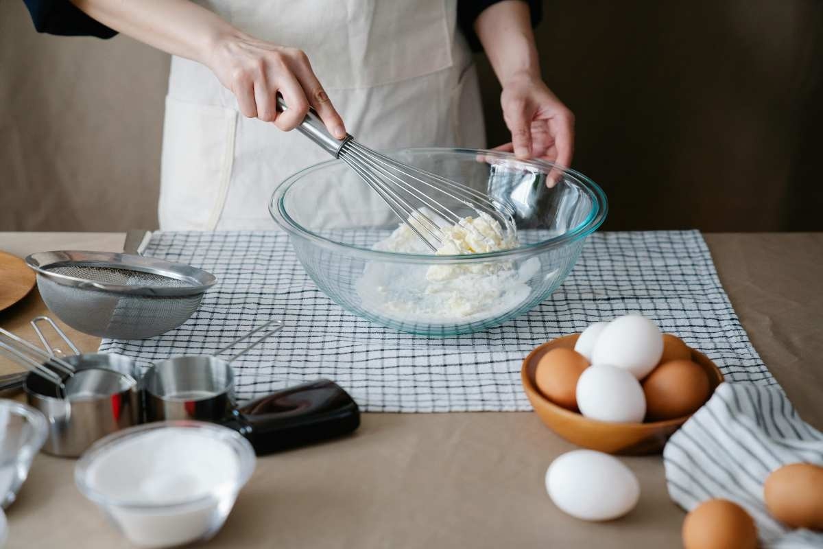 Prepararea aluatului pentru tarta cu caise_Persoana care prepara aluatul pentru tarta cu caise, ingrediente, echipamente si ustensile de bucatarie, masa
