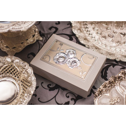 Caseta de bijuterii pe o masa alaturi de produse decor, cu capac auriu si 3 trandafiri suflati cu argint