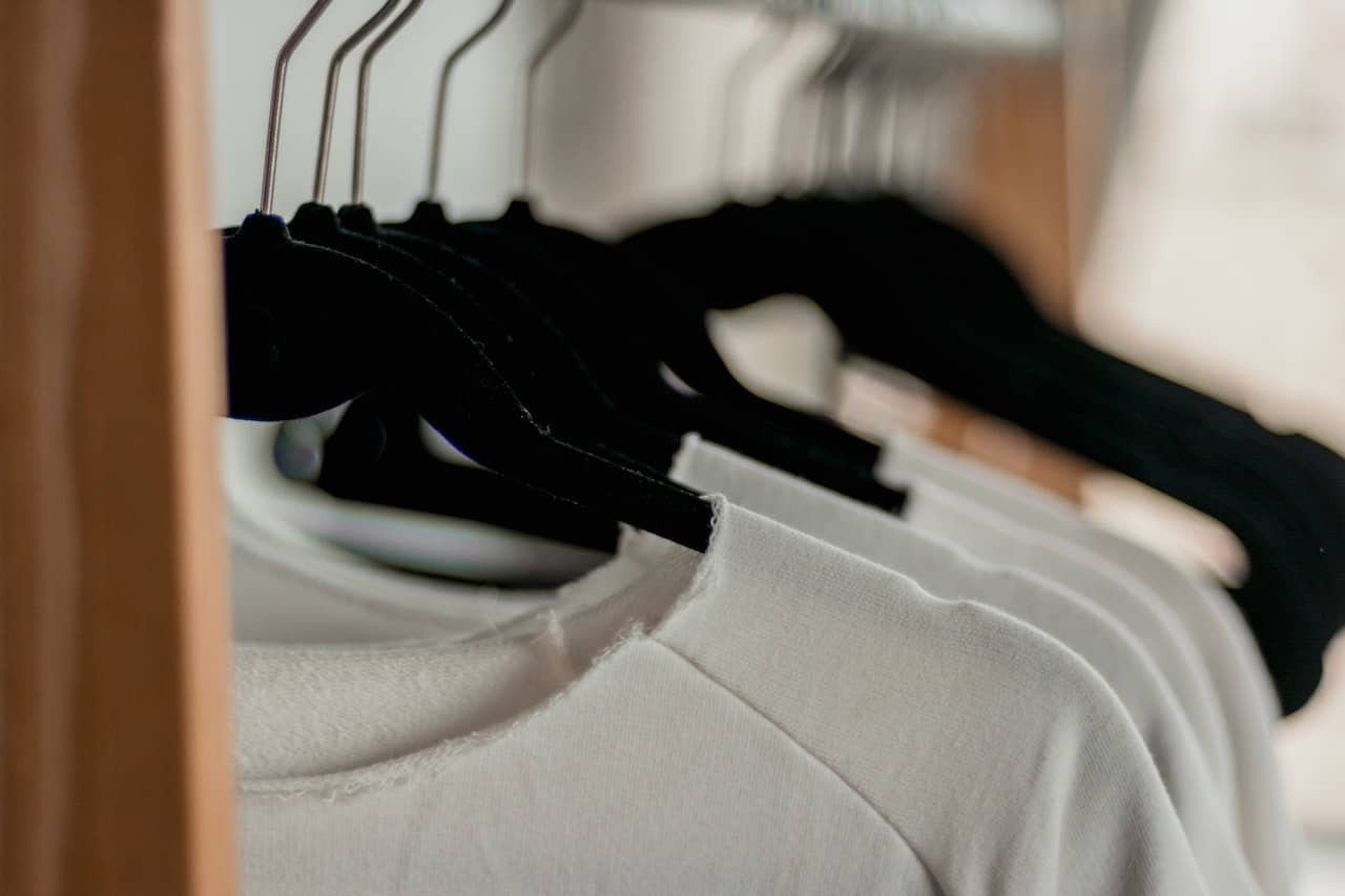 Organizarea hainelor in dulap - sfaturi practice - tricouri albe pe umerase negre
