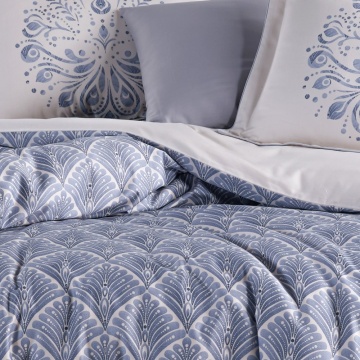 Detaliu lenjerie de pat din saten bumbac cu pilotă geometrică albastru prăfuit și fețe de pernă cu imprimeu decorativ