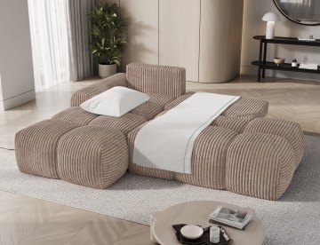 colțar Vittario bej taupe din material reiat extins în pat cu pernă și pătură albă