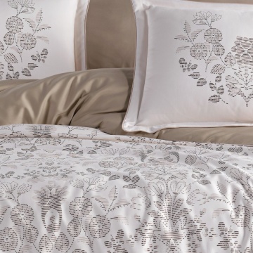 Detaliu lenjerie de pat din saten bumbac cu pilotă florală gri pe fundal alb și elemente uni bej nisipiu
