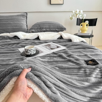 prim-plan cu mâna atingând pătura gri Jo-Jo Home, evidențiind textura 3D și blănița albă Sherpa de pe verso
