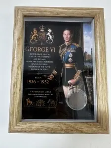 Tablou elegant, dimensiuni 14.8 x 19.8 cm, ce conține o monedă autentică din perioada regelui George VI (1936–1952), prezentată într-un design artistic inspirat din perioada Imperiului Britanic .