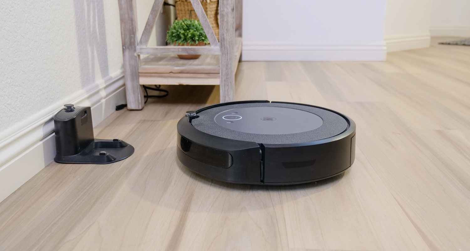 Aspirator robot cu stație de andocare completă, funcționând într-un living modern