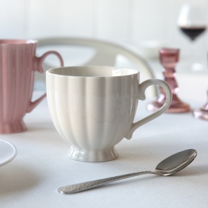 Ceasca portelan Curly, ce impresioneaza prin pliurile delicate, piciorul decorativ si manerul elegant