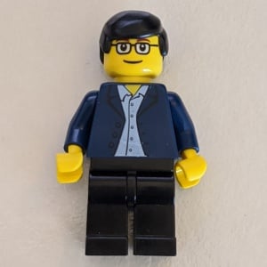 twn020G Man met donkerblauwe jas, lichtblauw shirt, zwarte benen, bril vierkant, zwart haar gebruikt *0M0000