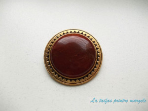 Golden brooch with round red agate