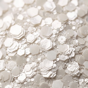 Detaliu macro cu fulgii de glitter perlat alb, hexagoane de mărimi diferite cu reflex sidefat