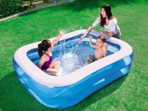 Copii și adult jucându-se într-o piscină gonflabilă Intex 57180NP amplasată pe gazon
