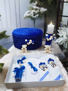 Set botez pentru băiețel în nuanțe de albastru regal, crem și alb cu cutie rotundă catifelată, lumânare decorată manual și trusou complet cu model ursuleț și baloane albastre