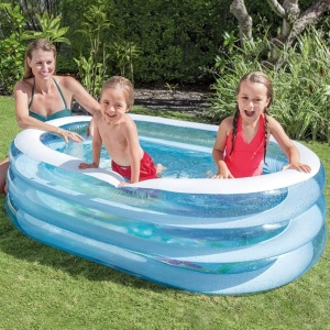 Copii jucându-se într-o piscină gonflabilă Intex Sea Friends amplasată pe gazon