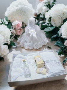 Set botez White Angel format din lumânare elegantă albă și trusou complet personalizat, prezentat într-un decor floral premium pentru botezuri elegante
