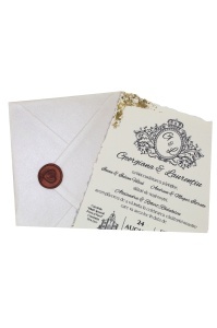 Detaliu invitație de nuntă personalizată cu monogramă elegantă, text clasic, margini cu foiță aurie și plic alb sigilat cu ceară.