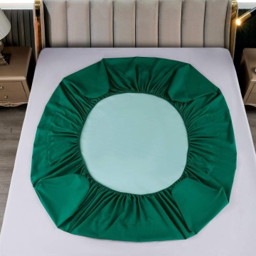 husa de culoare verde cu elastic, asezata pe pat