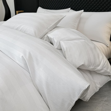 Lenjerie Damasc Deluxe alba Jojo Home asezata complet pe pat matrimonial cu aspect hotelier