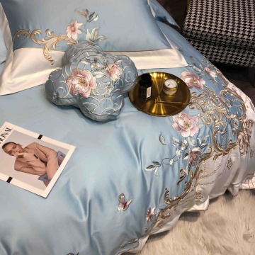 Detaliu lenjerie bleu JoJo Home cu broderie florală roz și aurie