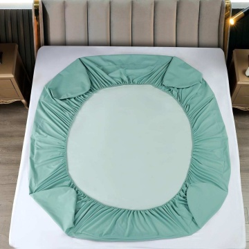 husa de culoare verde menta cu elastic, asezata pe pat