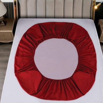 husa de culoare rosie cu elastic, asezata pe pat