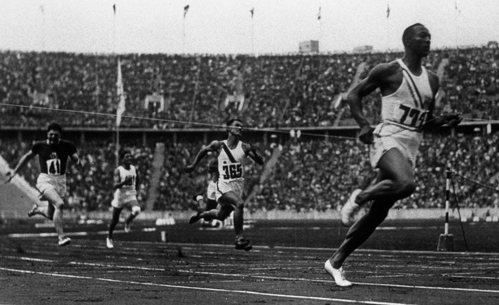 Jesse Owens alergand proba de 100m viteza in pantofii Drassler