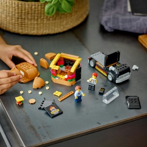 Tonetă mobilă LEGO City cu burger uriaș, camionetă și minifigurine vânzător și client, pregătită pentru aventuri culinare și jocuri de rol creative.