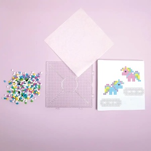 Copil realizând modele colorate din mărgele de călcat Unicorn Playbox, dezvoltând creativitatea, coordonarea mână-ochi și atenția la detalii.