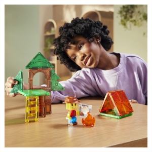 Set MAGNA-TILES Camp Out cu piese magnetice în culori naturale, figurină explorator, platforme, copaci și element decorativ cu foc de tabără.
