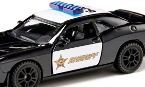 Model miniatural SIKU 1584 Dodge Challenger SRT County Sheriff, cu design inspirat de vehiculele șerifului american, uși care se deschid și detalii realiste din metal și plastic.