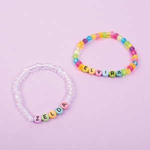 Set de 750 de mărgele alfabet Playbox în culori pastelate, inscripționate cu litere negre, pentru realizarea brățărilor, colierelor și accesoriilor personalizate.