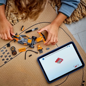 Set LEGO City Pilot F1 cu mașină de curse McLaren și minifigurină pilot, inspirat de competițiile Formula 1, pentru copii pasionați de vehicule și curse auto.