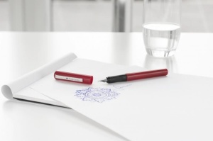 Stilou școlar Faber-Castell FC149812 roșu cu grip ergonomic și 6 cartușe de cerneală albastră, recomandat pentru elevii care învață să scrie corect și confortabil.