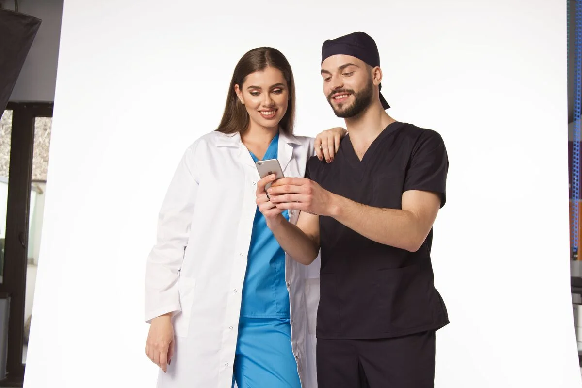 2. Atributii medic ortoped - femeie, barbat, telefon, uniforma de barbati pe negru, unforma de femei albastra