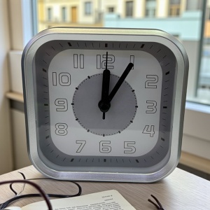 Ceas de masă analogic pătrat cu ramă gri metalizat și cadran alb, ideal pentru birou sau dormitor