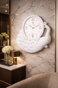 ceas decorativ alb în formă de păun elegant, cu cadran rotund și cifre aurii si strass-uri insertate