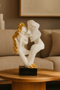 Statuetă artistică albă cu accente aurii, reprezentând un cuplu în îmbrățișare pasională