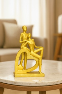 Figurină abstractă aurie cu cuplu romantic sprijinit de o inimă, simbol al iubirii