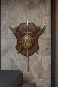 Decorațiune de perete stil medieval cu scut heraldic, armă verticală centrală și elemente decorative încrucișate, design cavaleresc clasic