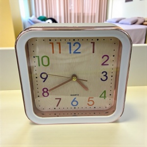 Ceas decorativ roz si alb cu afișaj analogic și cifre colorate, ideal pentru apartamente moderne,camere de copii, birou