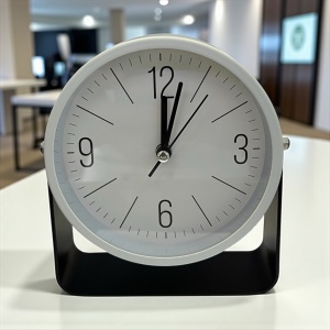 Ceas de masă minimalist cu ramă albă și suport negru, ideal pentru birouri moderne,spații de lucru si casa