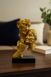 figurina aurie decorativă, chipurile unui cuplu de bătrâni îndrăgostiți, pe soclu negru
