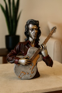 Figurină artistică reprezentând un cântăreț la chitară, decor elegant pentru pasionați de muzică