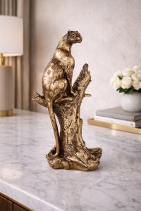Statuetă panteră elegantă argintie, așezată pe un trunchi de copac, simbol al puterii și grației