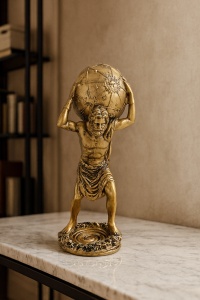 Figurină aurie cu Atlas din mitologia greacă ținând lumea pe umeri
